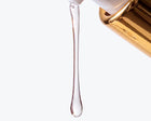 Close-up of a drop of clear SELAH gel falling from the gold pump